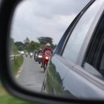 bikers form a queue behind a slow-moving car